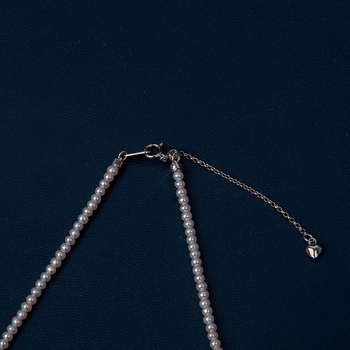 Édesvízi gyöngyökből készült nyaklánc, szinte kör alakú gyöngyök, 925-ös ezüst, rizs alakú gyöngyök díszítéssel, irodai minimalizmus stílus.