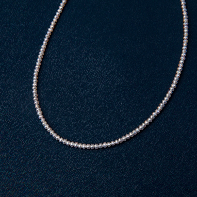 Édesvízi gyöngyökből készült nyaklánc, szinte kör alakú gyöngyök, 925-ös ezüst, rizs alakú gyöngyök díszítéssel, irodai minimalizmus stílus.