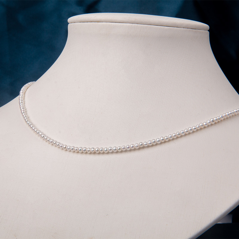 Édesvízi gyöngyökből készült nyaklánc, szinte kör alakú gyöngyök, 925-ös ezüst, rizs alakú gyöngyök díszítéssel, irodai minimalizmus stílus.