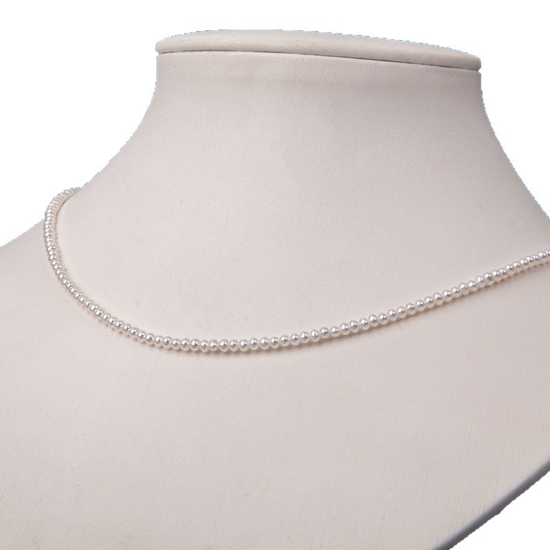 Édesvízi gyöngyökből készült nyaklánc, szinte kör alakú gyöngyök, 925-ös ezüst, rizs alakú gyöngyök díszítéssel, irodai minimalizmus stílus.
