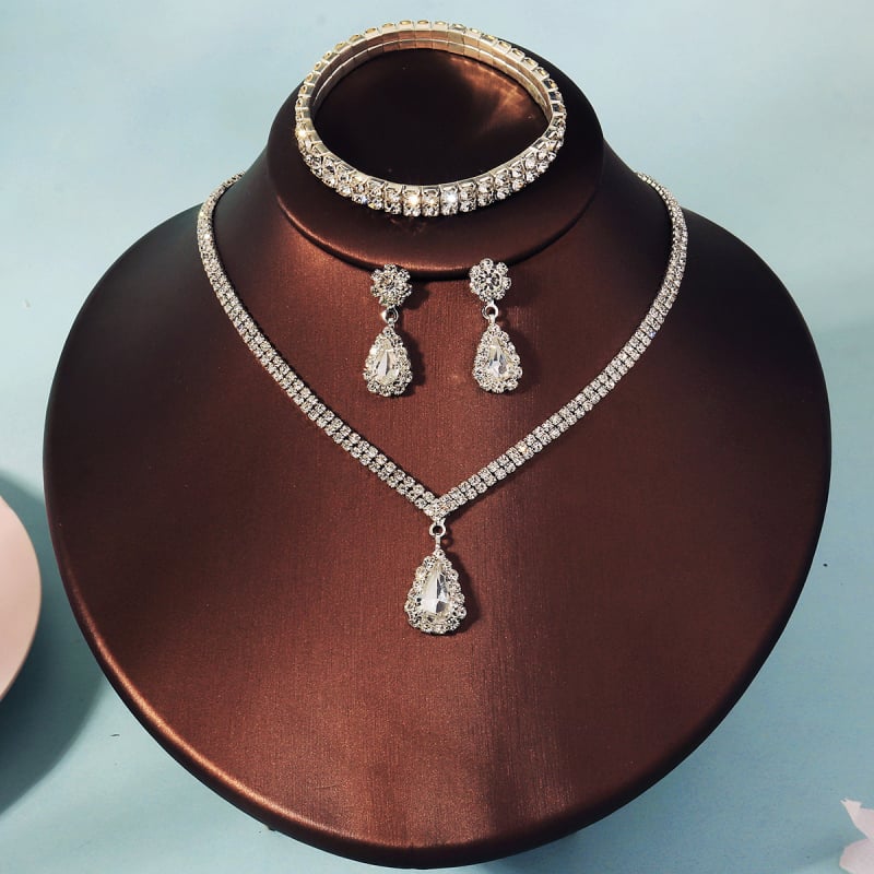 Háromrészes női ékszerszett: nyaklánc, fülbevaló és karkötő; üveg és lazurit lapis lazuli, gyémánt-stílus befejezés; réz medál egy hagyományos láncon; formák: szív, csepp, harang; márka Miallo; 2025 ősz