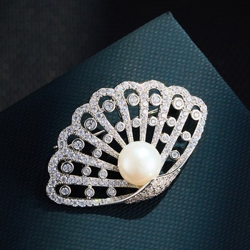 Kagyló alakú kitűző rézötvözetben mikro pavé cirkóniával és édesvízi gyönggyel, könnyed luxus stílusú női kiegészítő