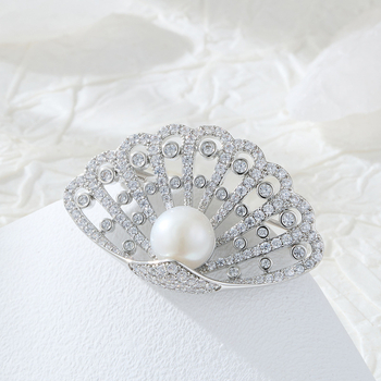 Kagyló alakú kitűző rézötvözetben mikro pavé cirkóniával és édesvízi gyönggyel, könnyed luxus stílusú női kiegészítő