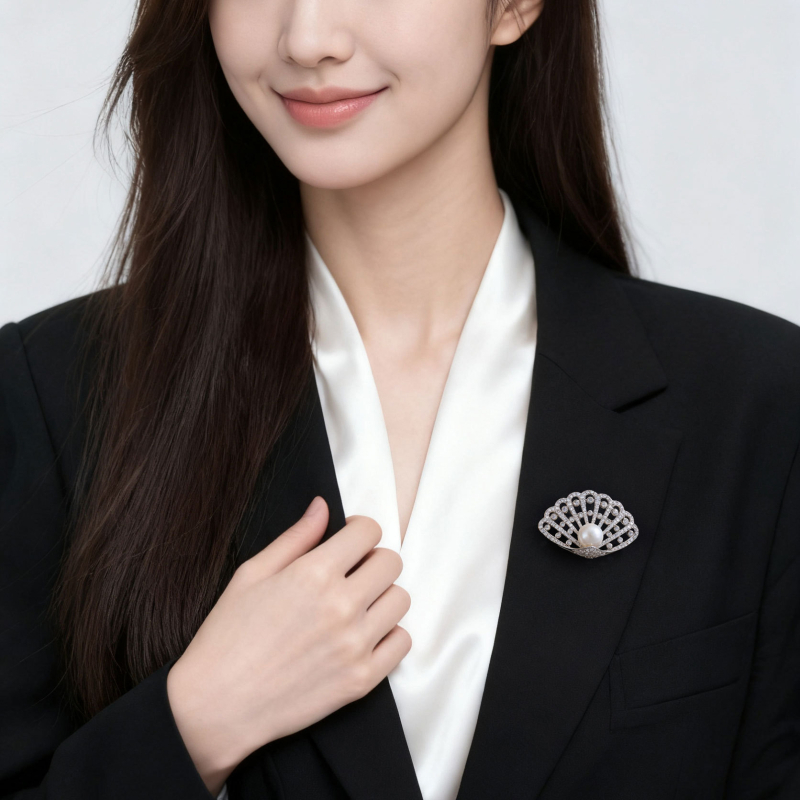 Kagyló alakú kitűző rézötvözetben mikro pavé cirkóniával és édesvízi gyönggyel, könnyed luxus stílusú női kiegészítő