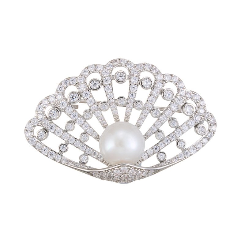 Kagyló alakú kitűző rézötvözetben mikro pavé cirkóniával és édesvízi gyönggyel, könnyed luxus stílusú női kiegészítő