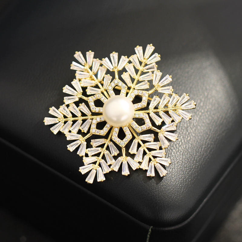 Broșă: bază din cupru placat cu aur, zircon în formă de fulg de zăpadă, formă geometrică, placare electrolitică
