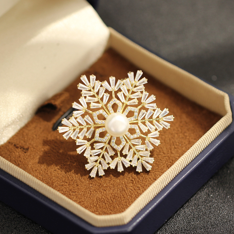 Broșă: bază din cupru placat cu aur, zircon în formă de fulg de zăpadă, formă geometrică, placare electrolitică