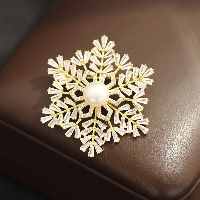 Broșă: bază din cupru placat cu aur, zircon în formă de fulg de zăpadă, formă geometrică, placare electrolitică