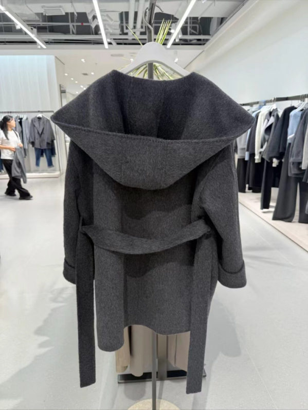 Ženski vuneni kaput s kapuljačom, slobodan kroj, sadržaj vune 50–70%, duljina 50–65 cm, zatvaranje šnalama, elegantan gradski stil, zima 2025