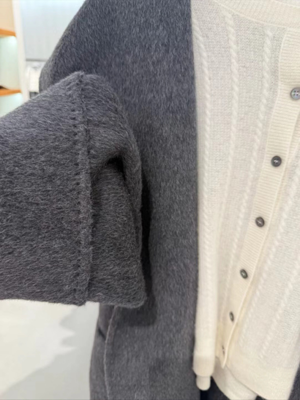 Ženski vuneni kaput s kapuljačom, slobodan kroj, sadržaj vune 50–70%, duljina 50–65 cm, zatvaranje šnalama, elegantan gradski stil, zima 2025