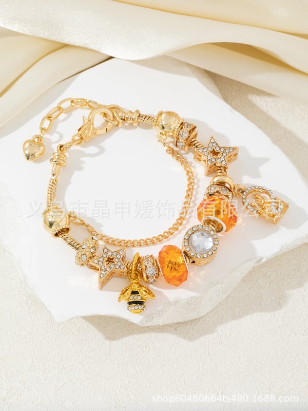 Karkötő – ötvözet, elektroplakált felület; uniszex dizájn; motívumok: vár, méh, ötágú csillag, óceán csillag kristályokkal.