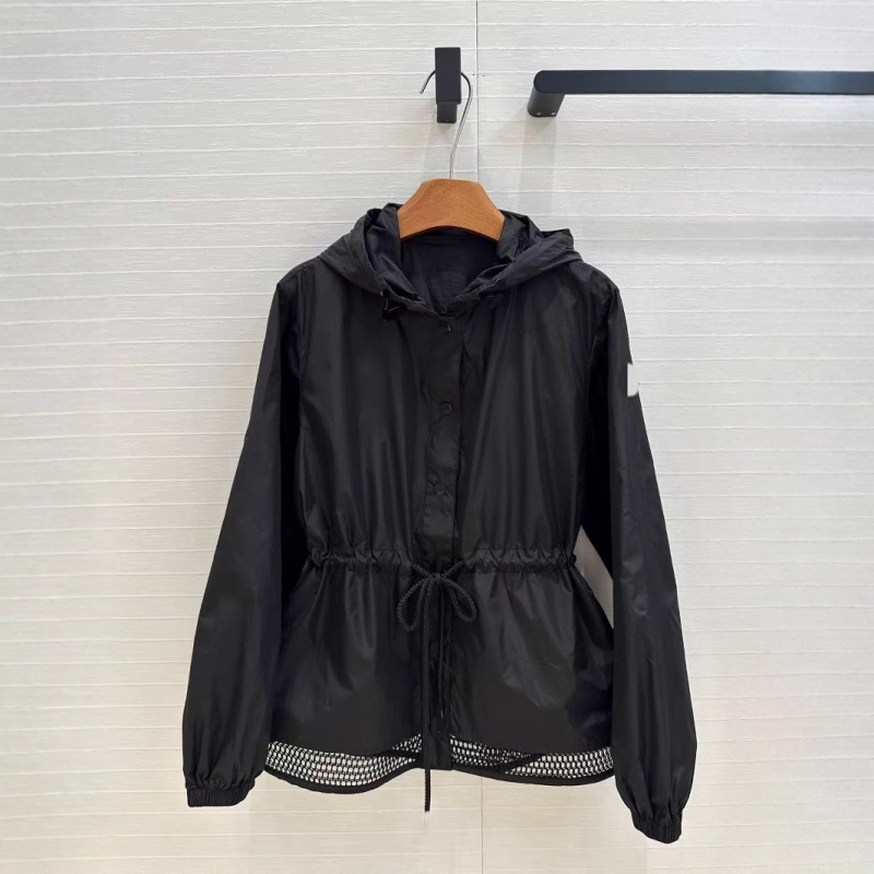 Kapuljačom pamučna windbreaker jakna s UV zaštitom, rezanim rubom i vezom u struku; podstava od pamuka, duljina 50–65 cm