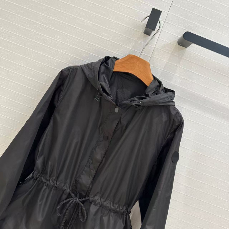 Kapuljačom pamučna windbreaker jakna s UV zaštitom, rezanim rubom i vezom u struku; podstava od pamuka, duljina 50–65 cm