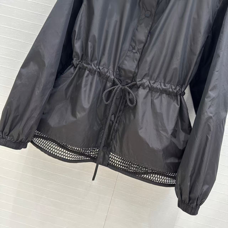 Kapuljačom pamučna windbreaker jakna s UV zaštitom, rezanim rubom i vezom u struku; podstava od pamuka, duljina 50–65 cm