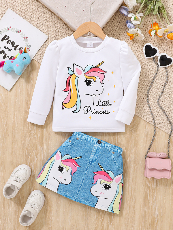 Két darabos gyermek szett: hosszú ujjú felső kereknyakú és unikornis mintával és mű denim szoknya; poliészter 95%; 3–8 éveseknek; tavasz 2025.