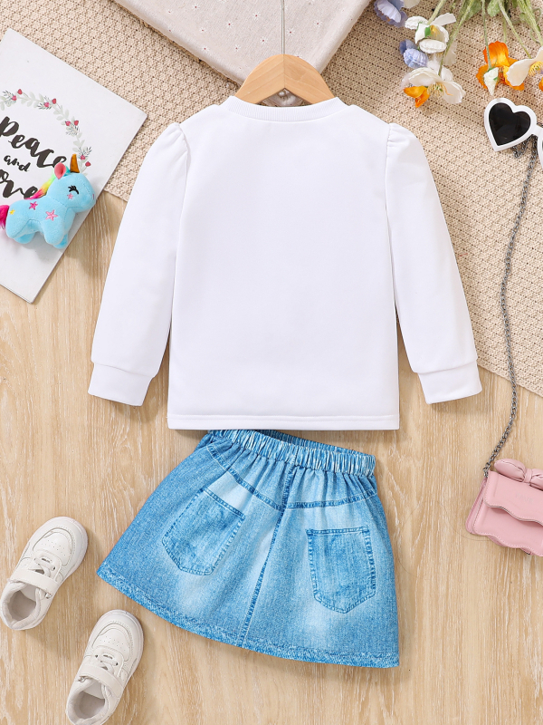 Két darabos gyermek szett: hosszú ujjú felső kereknyakú és unikornis mintával és mű denim szoknya; poliészter 95%; 3–8 éveseknek; tavasz 2025.