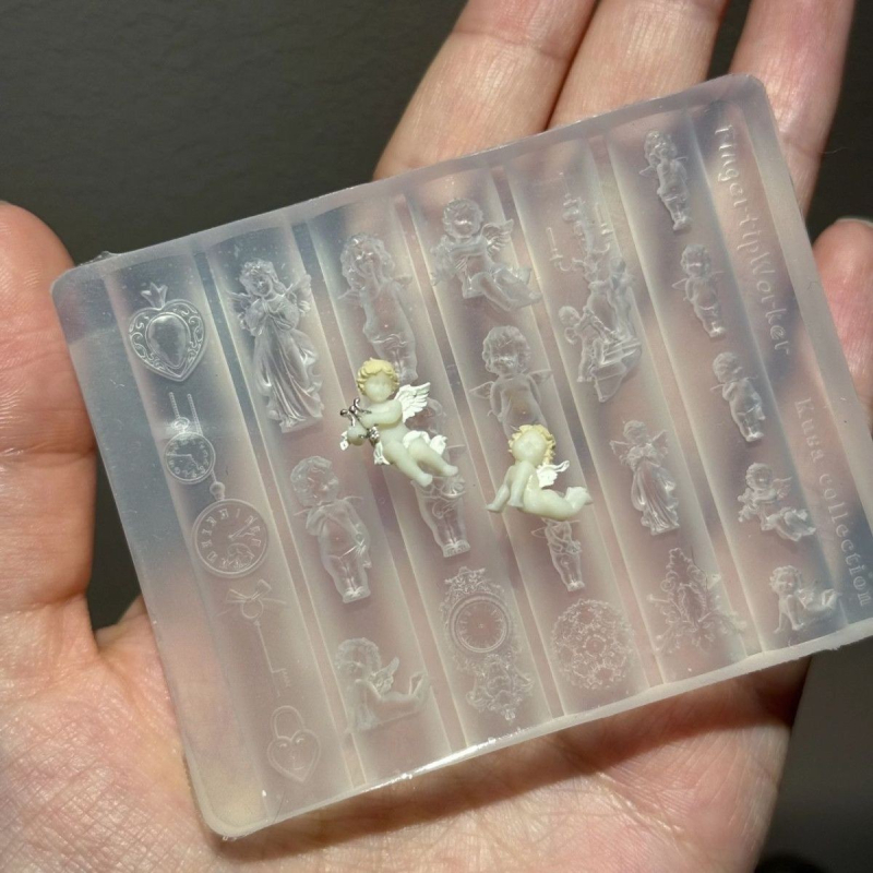 3D nagų formelė su motyvais: Mažasis Angeliukas, kišeninis laikrodis ir Meilės spyna; medžiaga: derva; reljefinis raštas; tinkama įprastam naudojimui