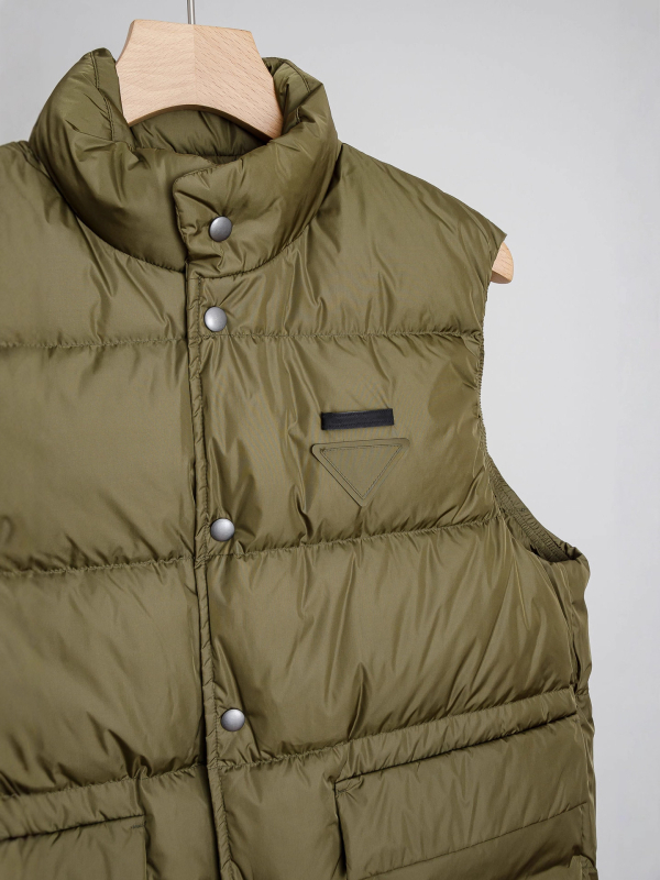 Жилетка с пухово съдържание 86–90%, пухово пълнеж 90, основна материя: полиестер, стойкова яка, 3D джобове с патч