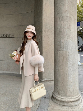 Palton reversibil din cașmir și lână, cu guler din blană de vulpe; palton scurt în stil cape; 70–80% lână; lungime 50–65 cm; croială lejeră.