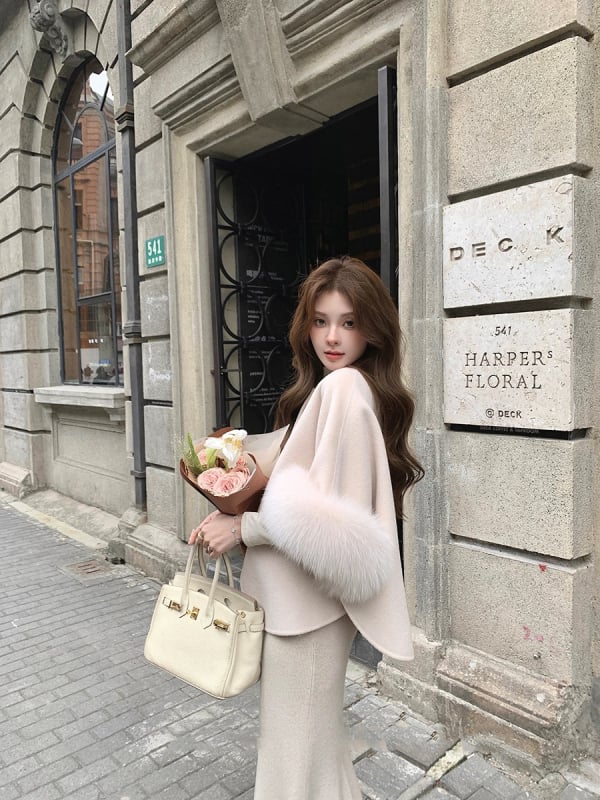 Palton reversibil din cașmir și lână, cu guler din blană de vulpe; palton scurt în stil cape; 70–80% lână; lungime 50–65 cm; croială lejeră.