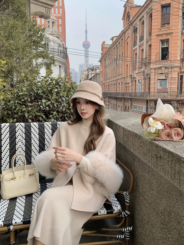 Palton reversibil din cașmir și lână, cu guler din blană de vulpe; palton scurt în stil cape; 70–80% lână; lungime 50–65 cm; croială lejeră.