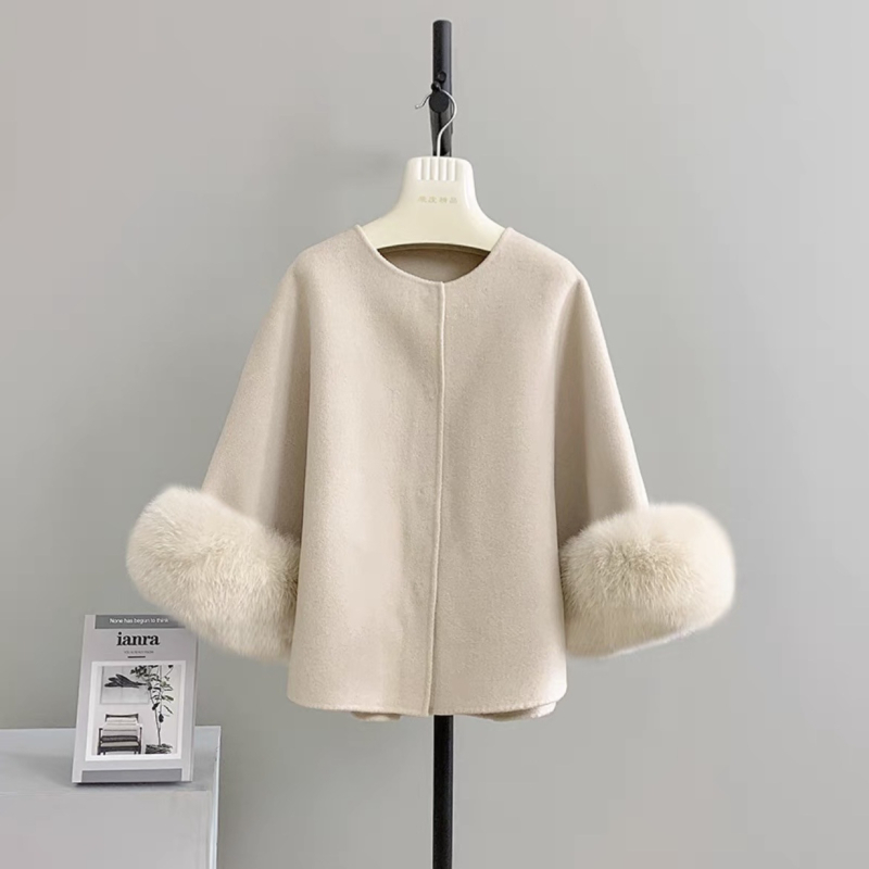 Palton reversibil din cașmir și lână, cu guler din blană de vulpe; palton scurt în stil cape; 70–80% lână; lungime 50–65 cm; croială lejeră.