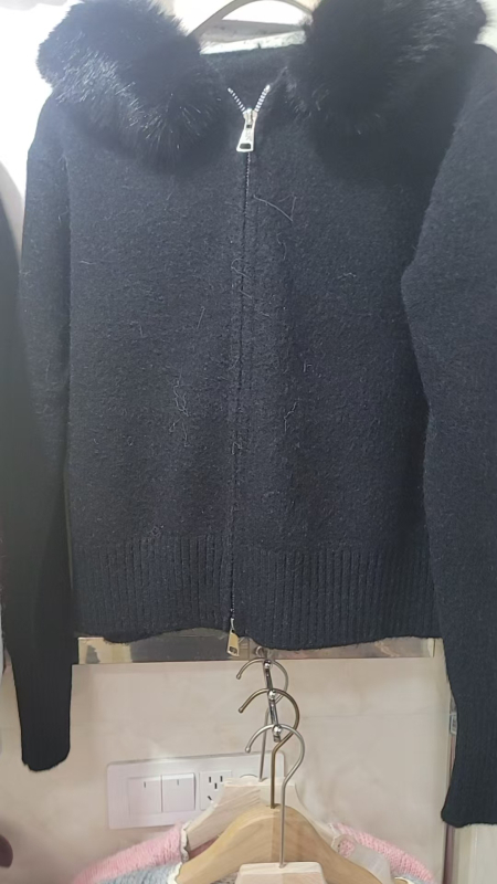 Ženski kapuljačasti debeli pleteni kardigan, smjesa poliester/akril/vuna, slobodan kroj, dugi rukavi, zip zatvarač, duljina 40–50 cm