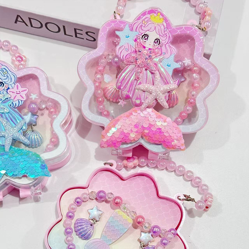 Meitenēm paredzēts jūras sirēnas astes un jūras gliemežu motīvs – kaklarota, gredzens un matu klipsi – materiāls PC – vecums 3–10 gadi – rudens 2025 izdevums