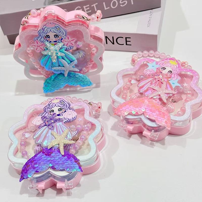 Meitenēm paredzēts jūras sirēnas astes un jūras gliemežu motīvs – kaklarota, gredzens un matu klipsi – materiāls PC – vecums 3–10 gadi – rudens 2025 izdevums