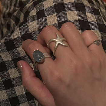 Nyitott geometriájú gyűrű matt felületű ötvözetből, tengeri csillag és macskaszem díszítéssel, elektroplatírozott