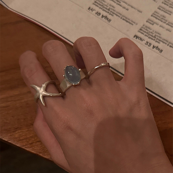 Nyitott geometriájú gyűrű matt felületű ötvözetből, tengeri csillag és macskaszem díszítéssel, elektroplatírozott