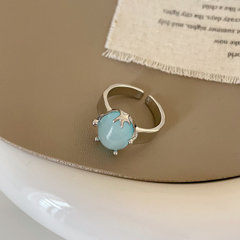 Nyitott geometriájú gyűrű matt felületű ötvözetből, tengeri csillag és macskaszem díszítéssel, elektroplatírozott