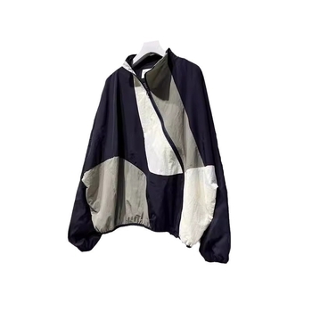 Ženska windbreaker jakna s dijagonalnim plaktom i kontrastnim šavovima, slobodan kroj, srednja duljina, polu-visoki ovratnik, dugi rukavi, poliester 70–80%