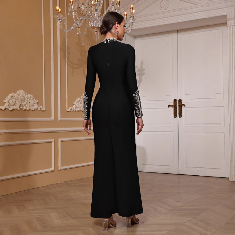 Duga večernja haljina s dugim rukavima, uski kroj, ukrašena perlicama i zatvaračem, materijal poliester-elastan.