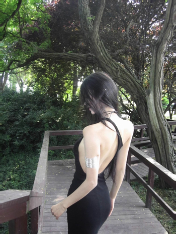 Haljina od poliestera, bez rukava, šikim ovratnikom, srednje duljine, kroj na bokove, srednji pojas, stil nagnutih ramena, kraljevski stil sestre