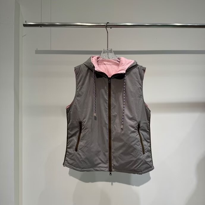 Ženska dvostrano lagana vest s kapuljom i zatvaračem, slobodnog kroja; sadržaj perja 86–90% bijelog patka perja; glavna tkanina poliester s elastanom