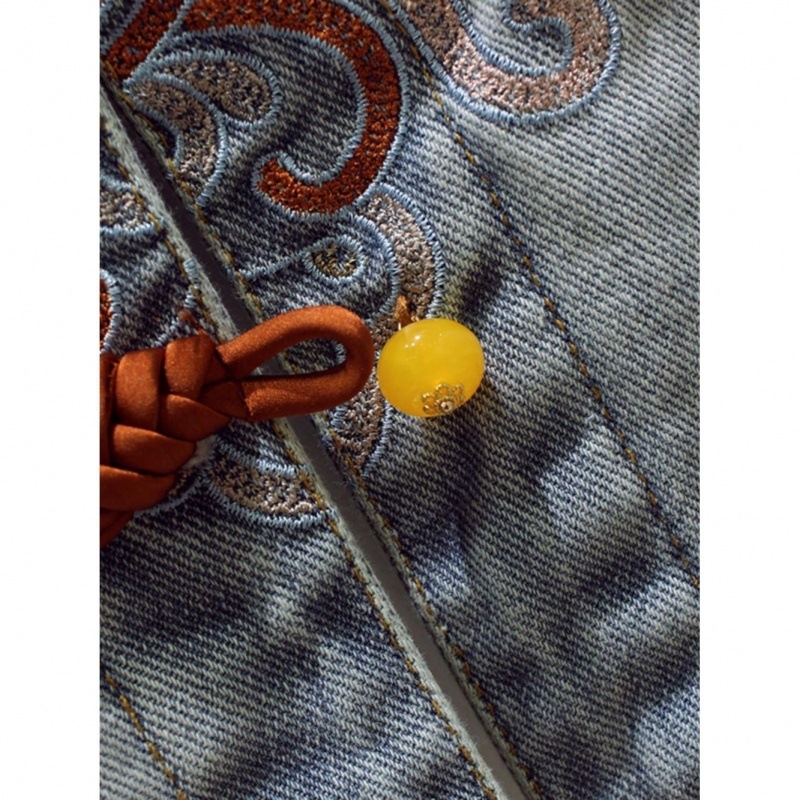 Női denim kabát álló gallérral, egysoros gombolás, hímzett állatmotívum, laza szabás, középhosszú.