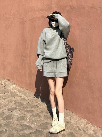 Set din două piese: top din trening cu guler rotund și fustă scurtă, material Space Cotton, poliester și alte fibre; lansare toamnă 2025.