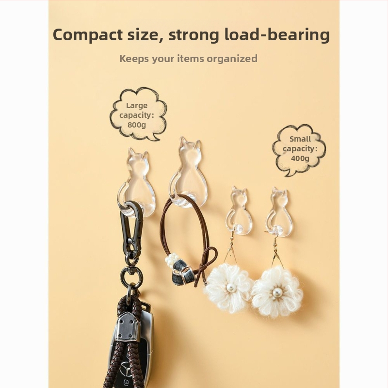 Caurskatāms sveķu kaķa motīva āķis – sienai bez urbšanas, vienkāršs karikatūras stils, maksimālā slodze 0–1 kg, izlaidums 2025