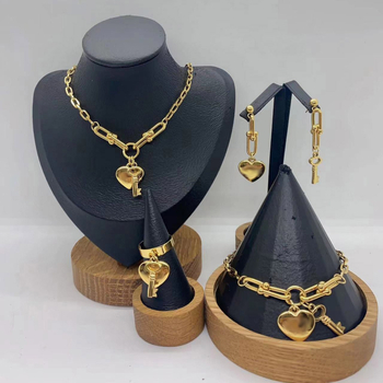 Set de bijuterii din oțel inoxidabil: pandantiv inimă, cheie, lanț în formă de U, brățară și colier; pandantiv din plexiglas; formă feminină; lanț de tip regular; număr de producție N001