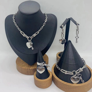 Set de bijuterii din oțel inoxidabil: pandantiv inimă, cheie, lanț în formă de U, brățară și colier; pandantiv din plexiglas; formă feminină; lanț de tip regular; număr de producție N001