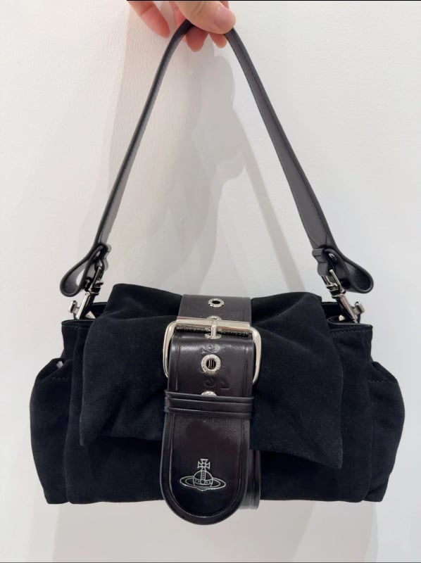 Velūro formos rankinė su kaspinu, dangtelio užsegimas, vidinė kišenė su užtrauktuku ir viena pečių juosta