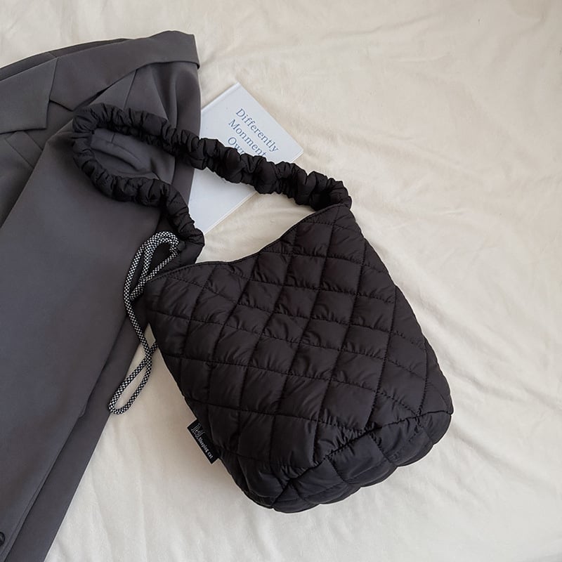 Kviltuotas lengvas kibiro tipo rankinukas – poliesteris, magnetinis užsegimas, vidinė kišenė su užtrauktuku, vienas peties dirželis