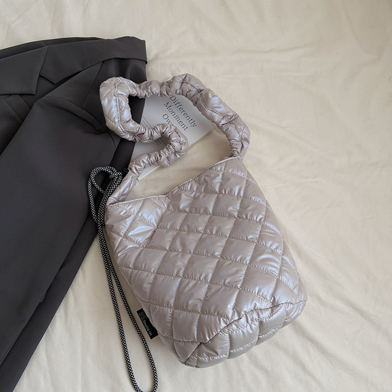 Kviltuotas lengvas kibiro tipo rankinukas – poliesteris, magnetinis užsegimas, vidinė kišenė su užtrauktuku, vienas peties dirželis