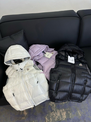 Unisex pūkų liemenė su gobtuvu, 200 g balto antis pūkų, laisvas siluetas, užtrauktukas, kelios kišenės, tinkama pavasariui, rudeniui ir žiemai, poliesterio audinys