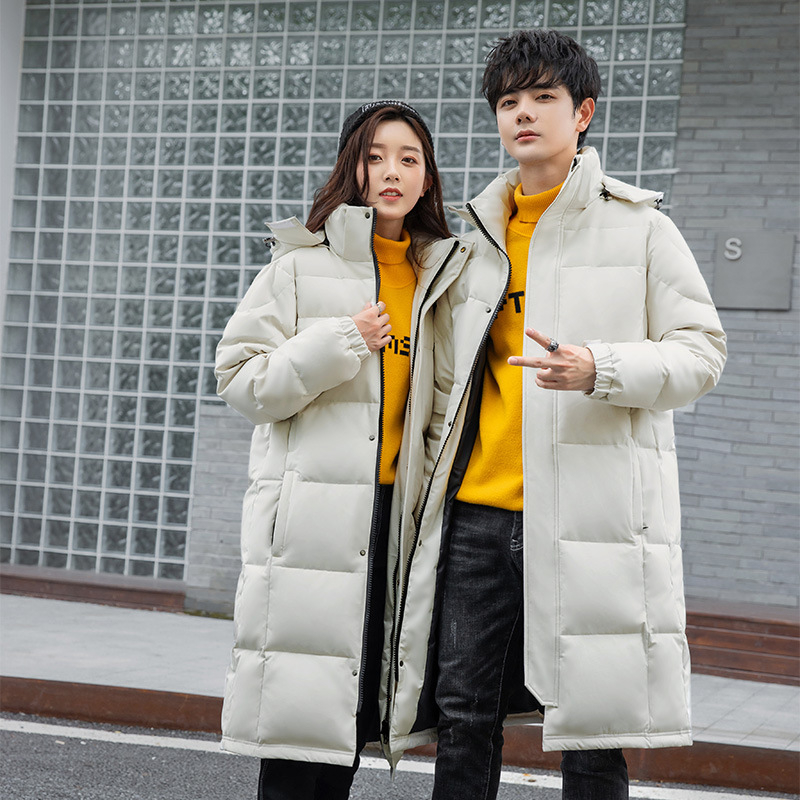 Geacă de iarnă lungă, cu glugă, închidere cu fermoar, umplutură din puf de gâscă 86–90%, lungime extinsă pentru iarnă.