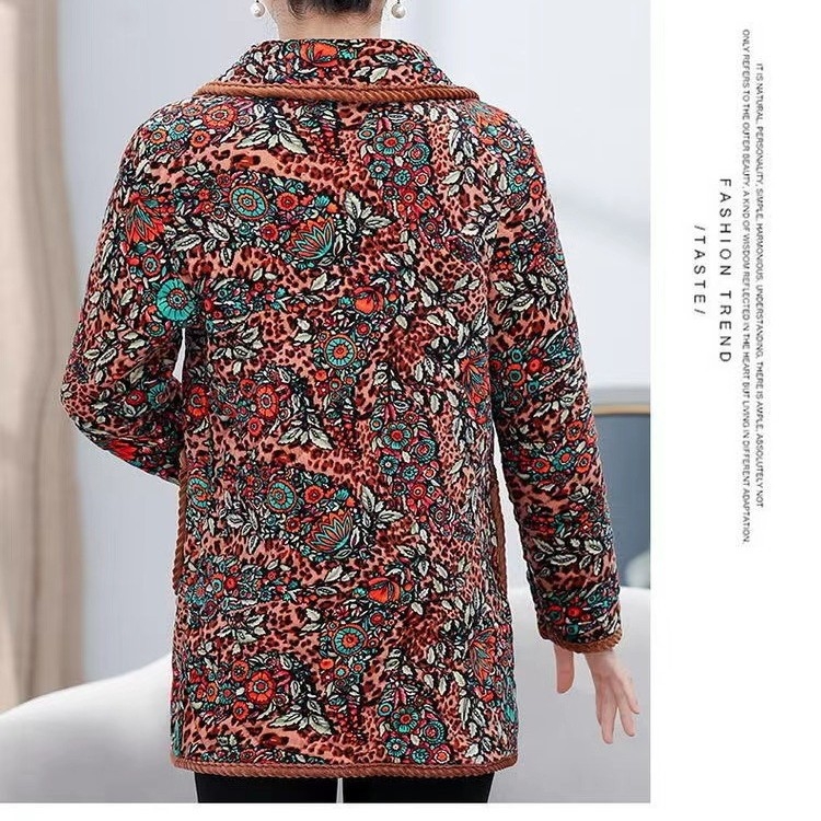 Žieminis šiltas moterų paltas vyresniems žmonėms, su spauda, storu fliso pamušalu, vidutinio ilgio, laisvas kirpimas, priekyje vienos eilės mygtukais; audinys Cupro ir poliesterio mišinys, užpildas iš šilką primenančių pluoštų