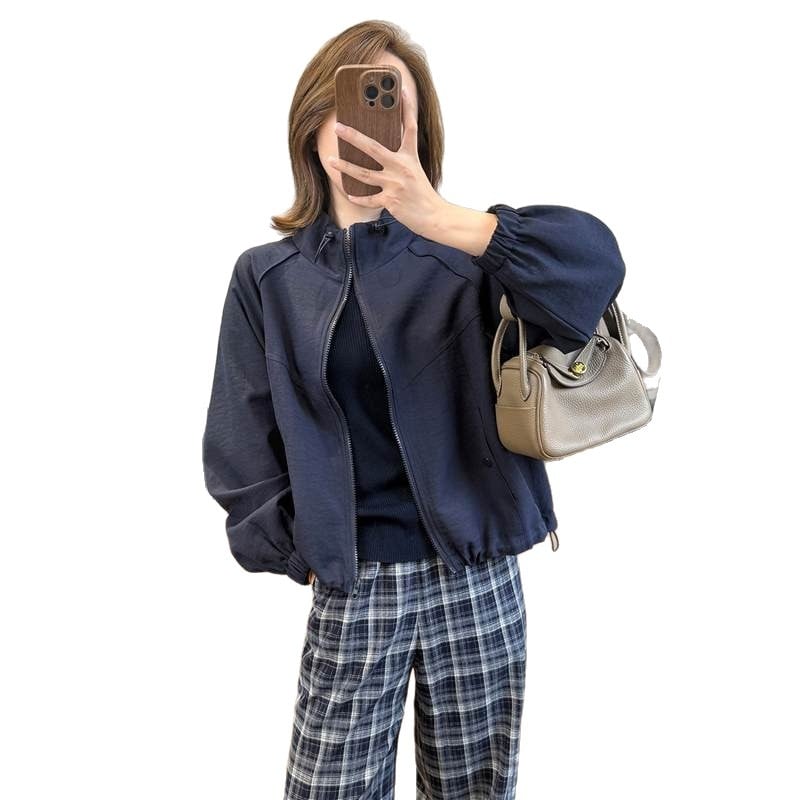 Casual kratka jakna s stojećim ovratnikom i raglan rukavima — poliester 70–80%, jednobojna, duljina 40–50 cm, zatvarač, slobodan kroj