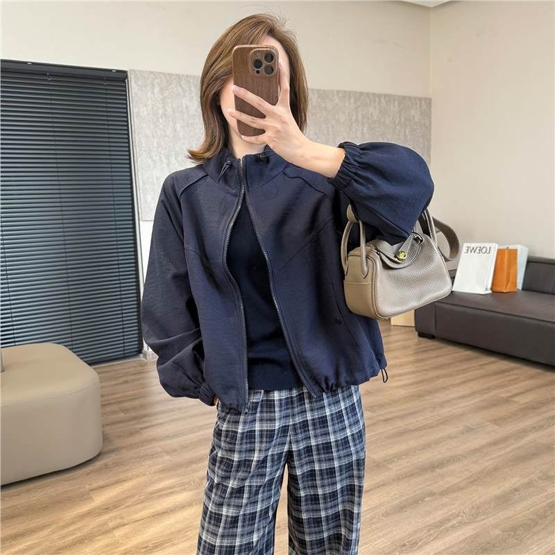 Casual kratka jakna s stojećim ovratnikom i raglan rukavima — poliester 70–80%, jednobojna, duljina 40–50 cm, zatvarač, slobodan kroj