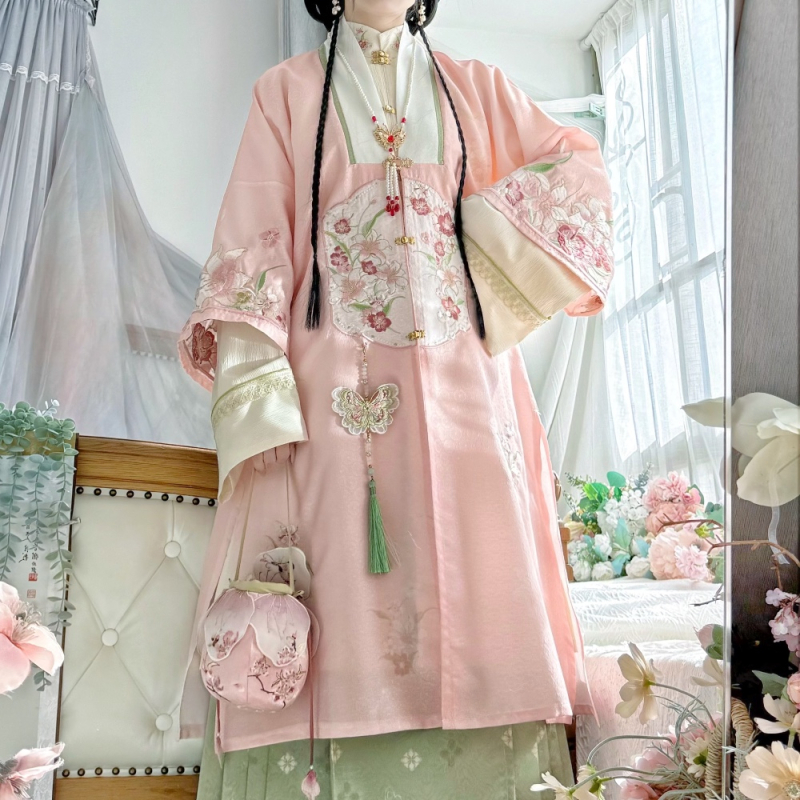 Hanfu szett: hosszú köntös álló gallérral és elöl nyíló felsőrész, hímzett; anyaga poliészter 30–50% regenerált cellulózrosttal; 2024 tavaszi kiadás